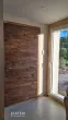 Entrée d’une maison neuve à Ventabren avec porte bois et éclairage mural